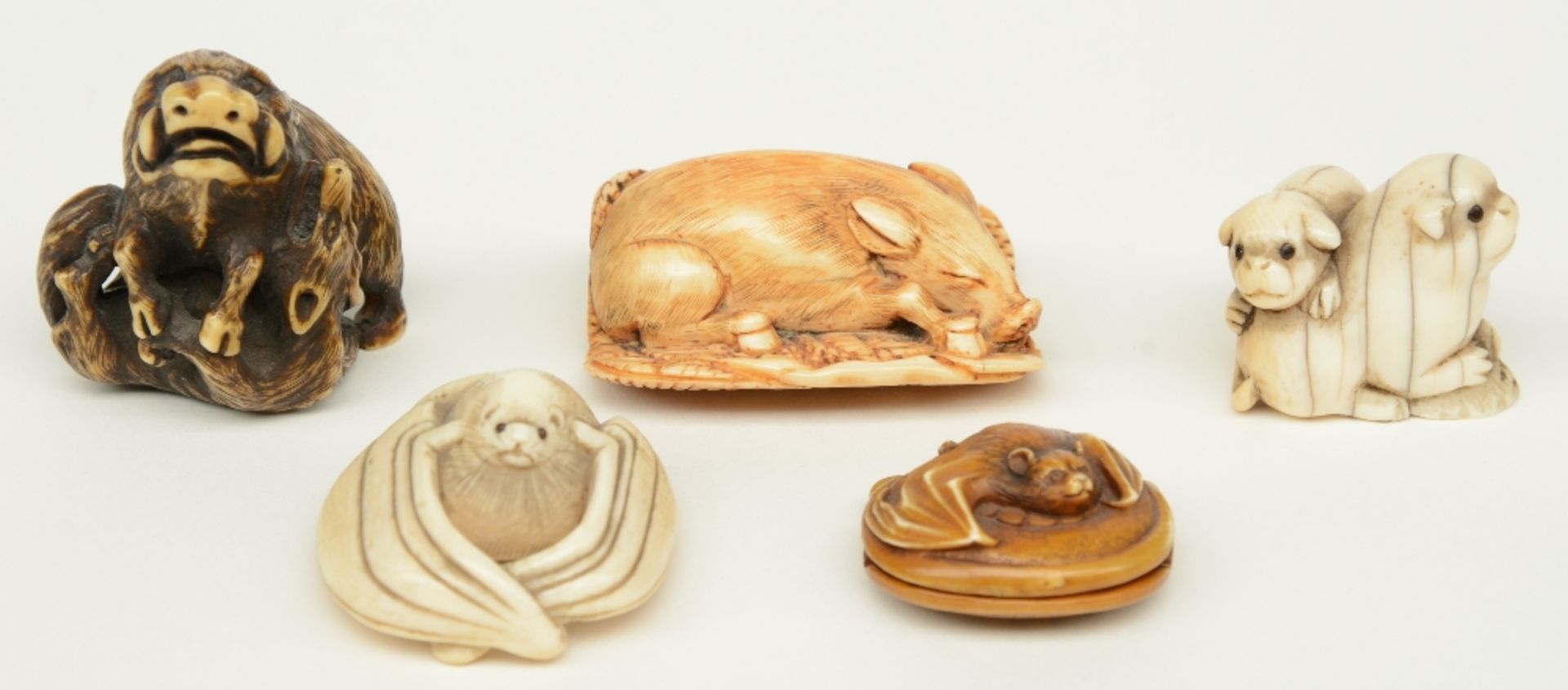 Four late Edo period Japanese ivory katabori-netsuke, in the form of a boar fighting with a fox, a