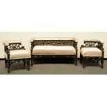 A Neoclassical ebonized sofa, richly carved, and two ditto corner chairs, H 67 - W 51 - 124 - D 51 -