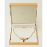 A pearl necklace with an 18ct gold pendant set with brilliant cut diamonds and a cabochon cut