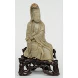 A Chinese steatite sculpture representing a Guanyin, on a wooden base, 18th/19thC, H 20,5 cm (with