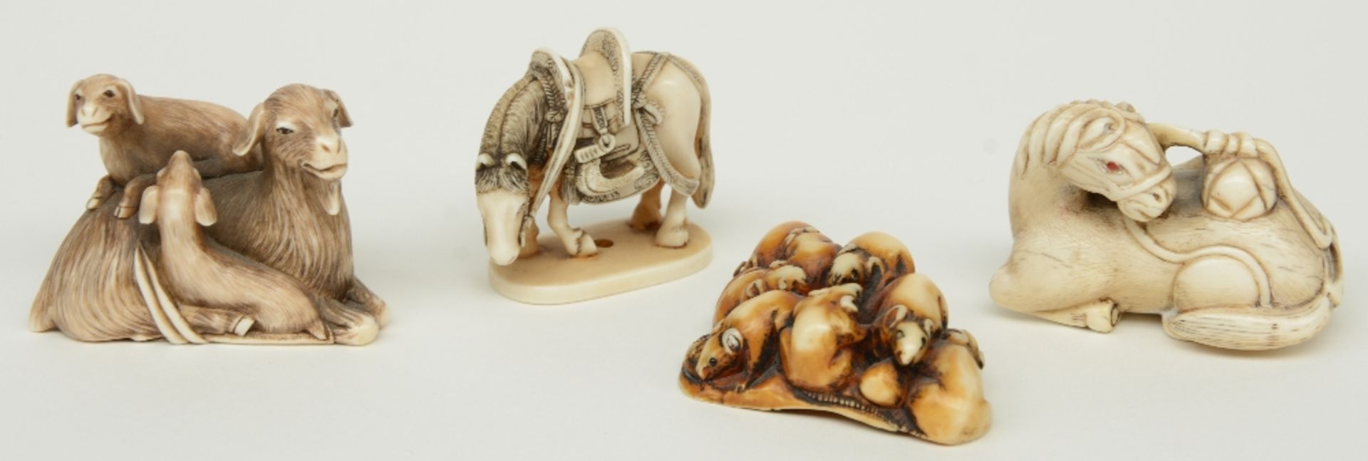 Four late Edo period Japanese ivory katabori-netsuke, two in the form of horses, one in the form