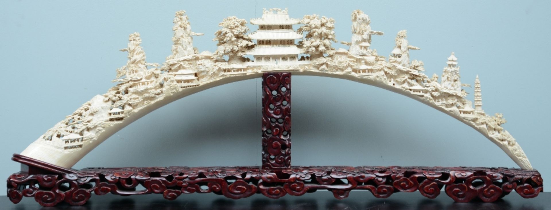 An exceptional Chinese richly carved ivory tusk, depicting various temples and pagodes in a