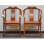 A pair of Chinese armchairs in exotic wood, the horseshoe-shaped back richly carved and crowned with
