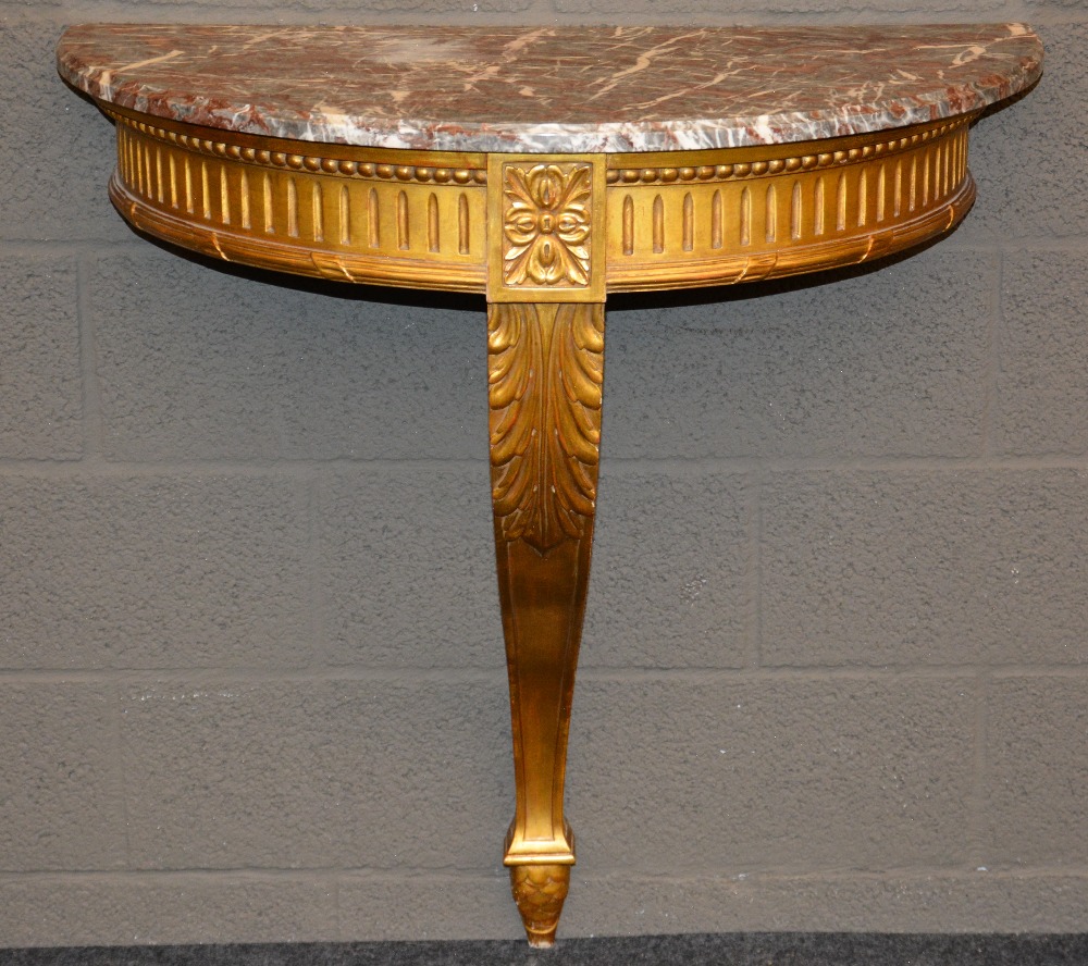 A gilt wooden demi-lune LXVI style console table with 'rouge royal' top, H 86 - W 82 - D 44 cm