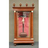 A first half of the19thC mahogany display cabinet, inside a crucifix with a polychrome painted