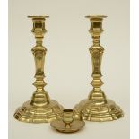 A pair of second quarter of the 18thC brass candle sticks with traces of plate; added an 18thC brass