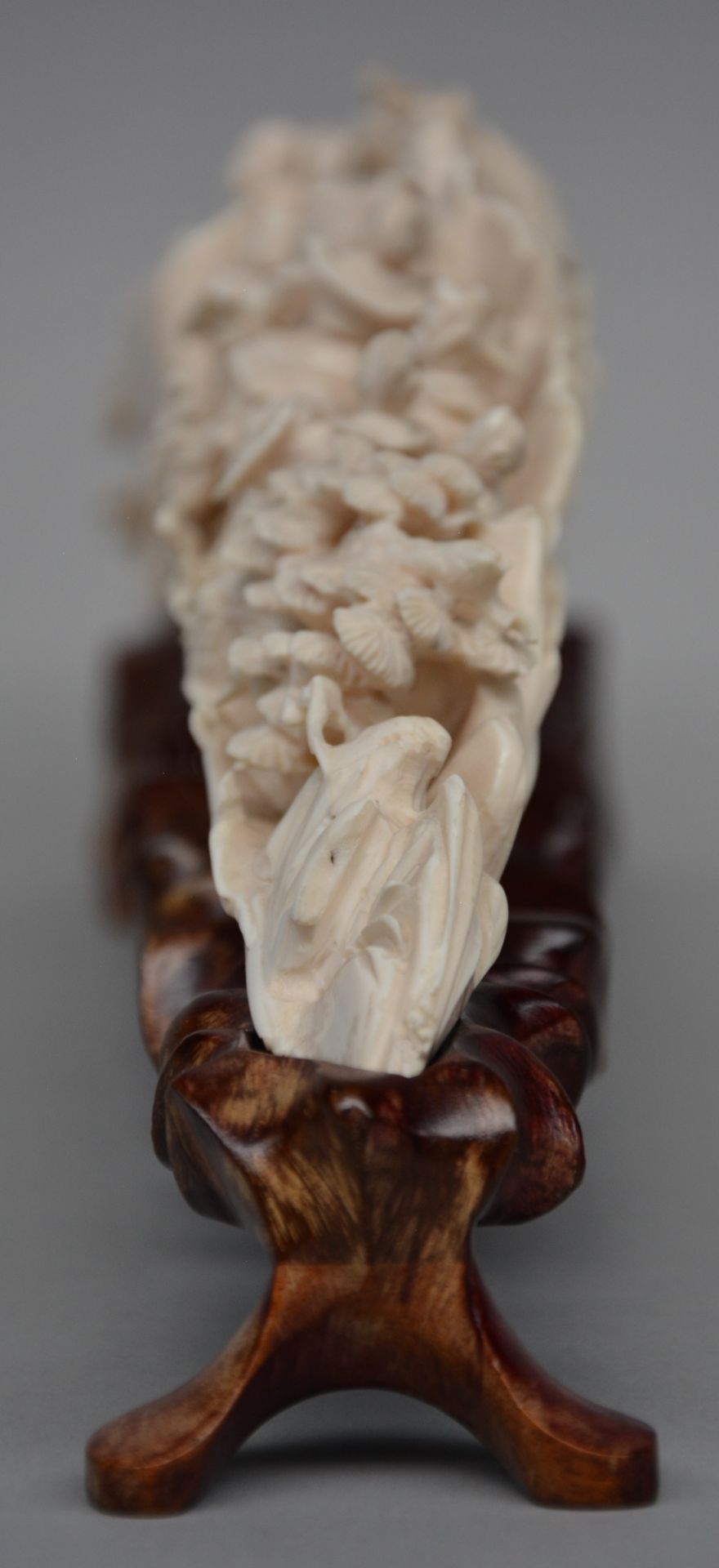 An ivory tusk carved with animated scenes, on a matching wooden base, first half of 20thC, L 45,5 cm - Image 2 of 7