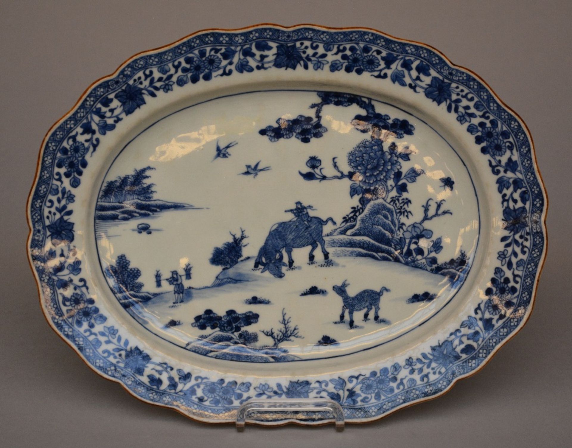 A Chinese oval dish with profiled rim, blue and white decorated with a landscape and floral - Bild 2 aus 5