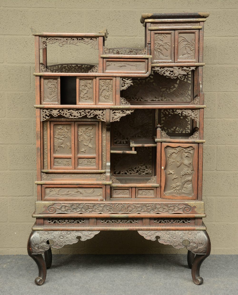 A Japanese wooden display cabinet, carved with birds, flowerbranches and a landscape, ca. 1900, H