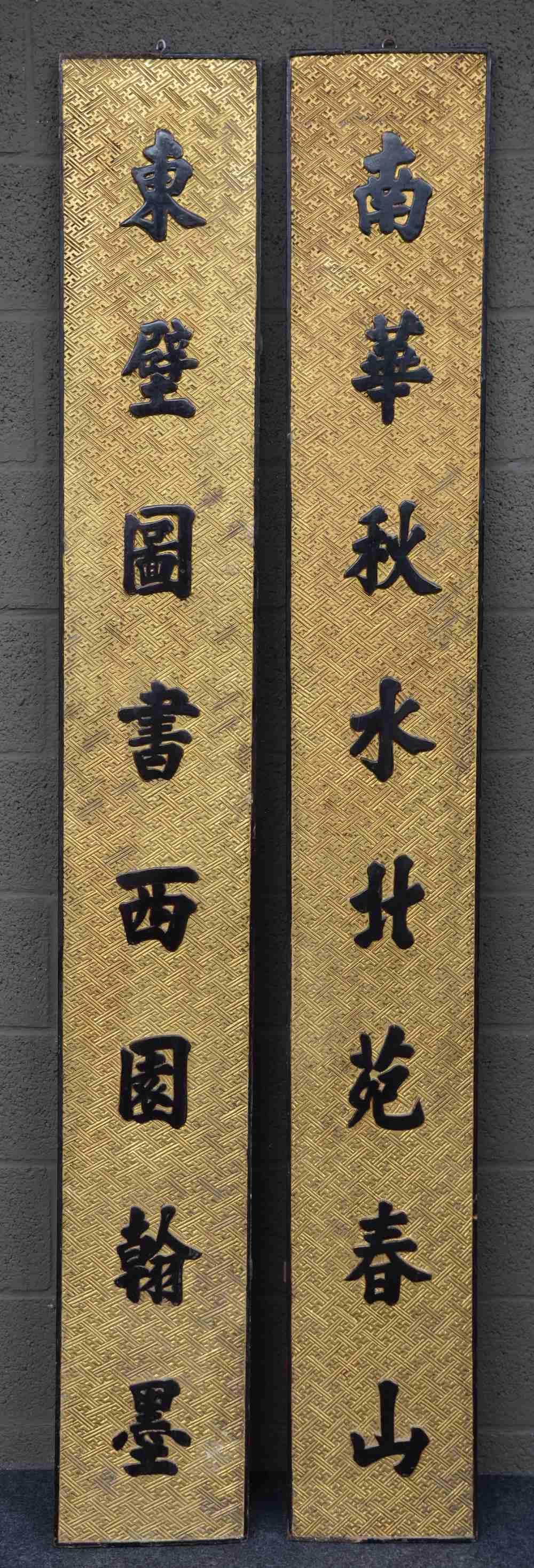 A pair of Chinese gilt and polychrome relief moulded wooden panels with lacquered inscriptions, H