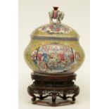 A Chinese yellow ground famille rose pot decorated with court scenes and warriors, on a wooden base,