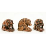 Three Japanese wooden katabori netsuke depicting wolves defending their prey, early Meiji-period,