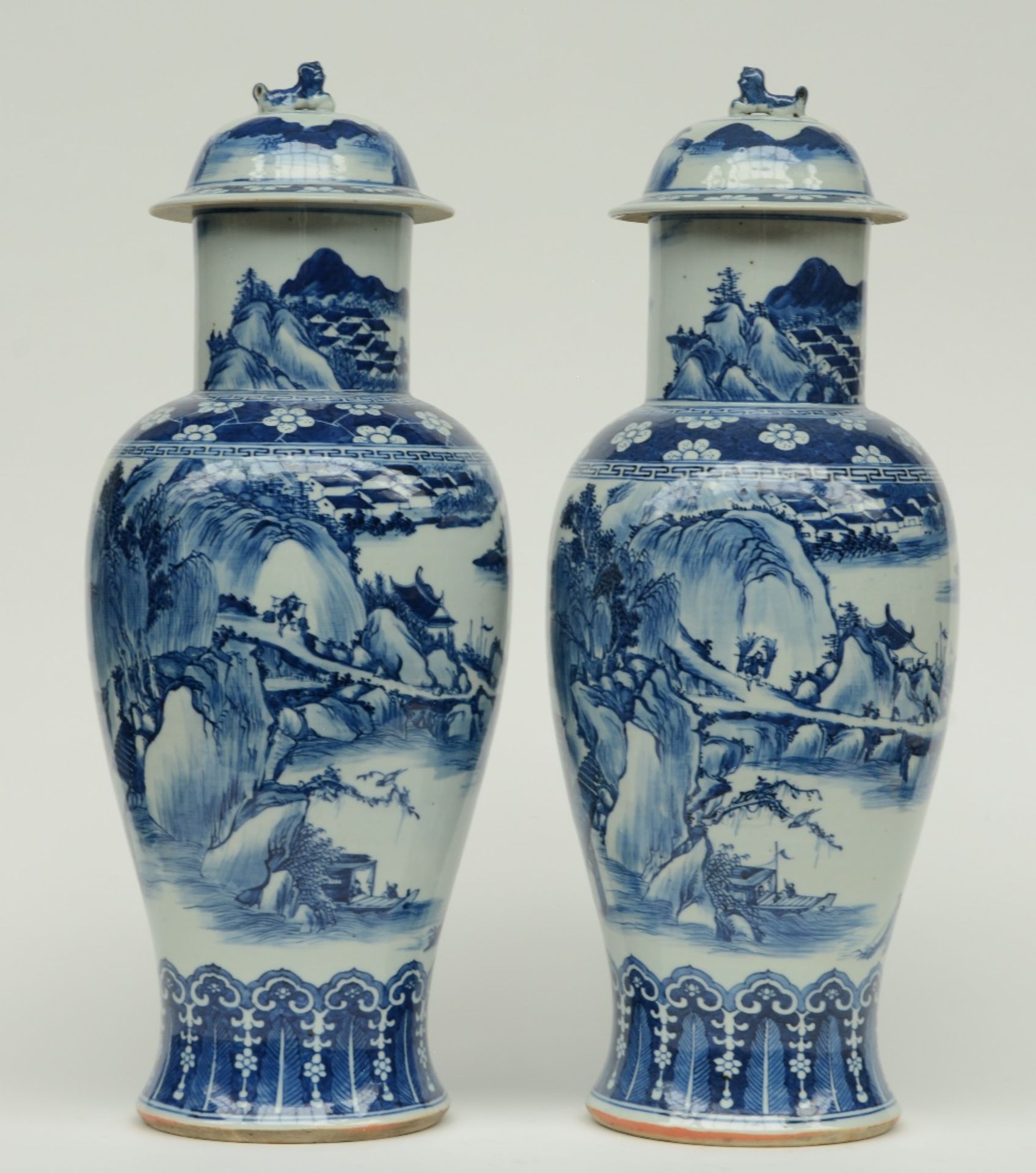 A pair of Chinese blue and white baluster shaped vases with cover, overall decorated with a river