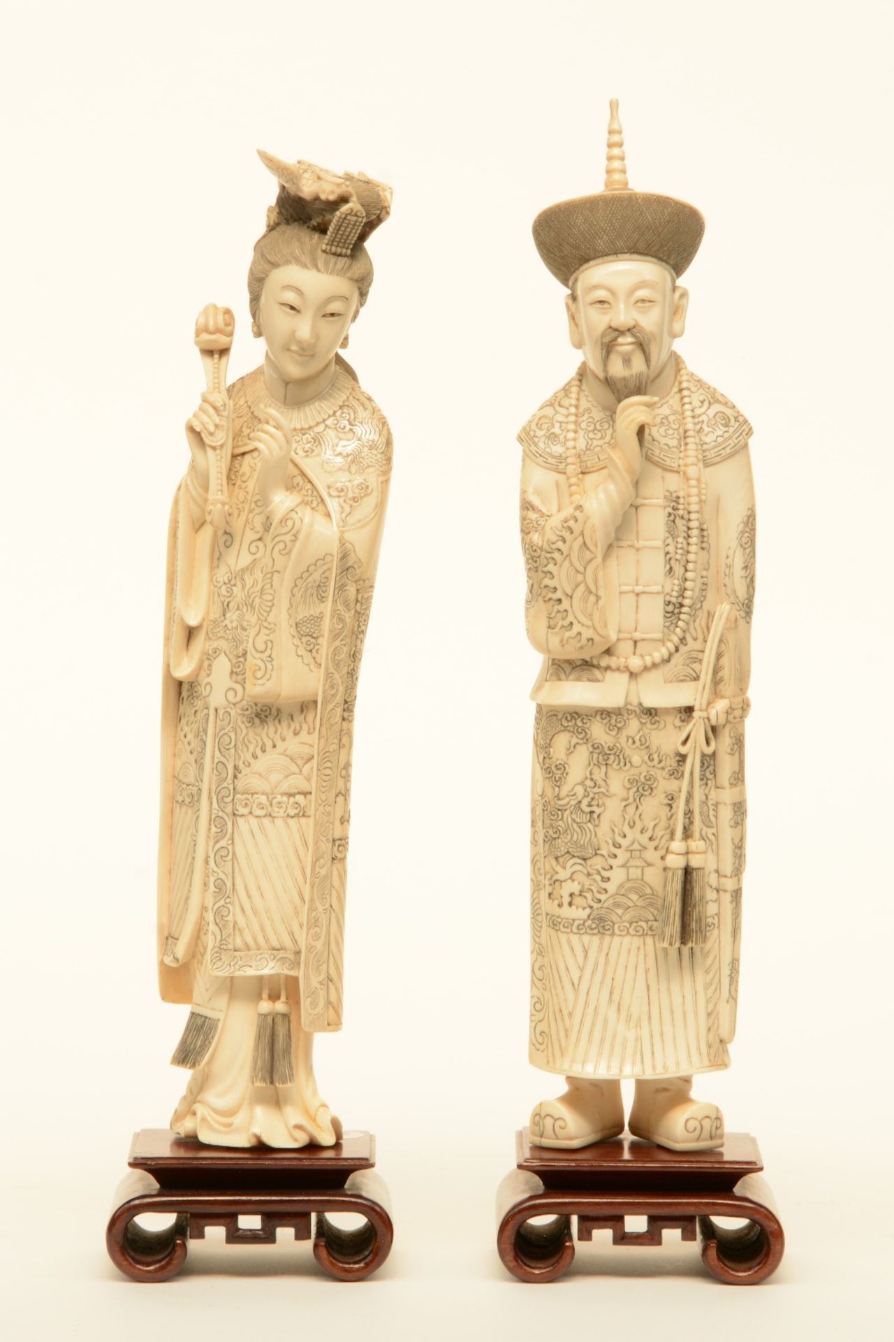 A pair of Chinese ivory dignitaries, on wooden base, late 19thC, H 37,5 - 39,5 cm - Weight: ca. 1129