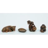 Three Japanese wooden katabori netsuke, one depicting a buffalo at rest, one a monkey playing with a