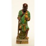 An earthenware roof-figure depicting one of the Immortals, brown, yellow and green enameled,