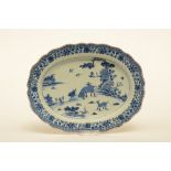 A Chinese oval dish with profiled rim, blue and white decorated with a landscape and floral