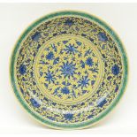 A Chinese large yellow ground and green dish with a blue and white floral decoration, marked