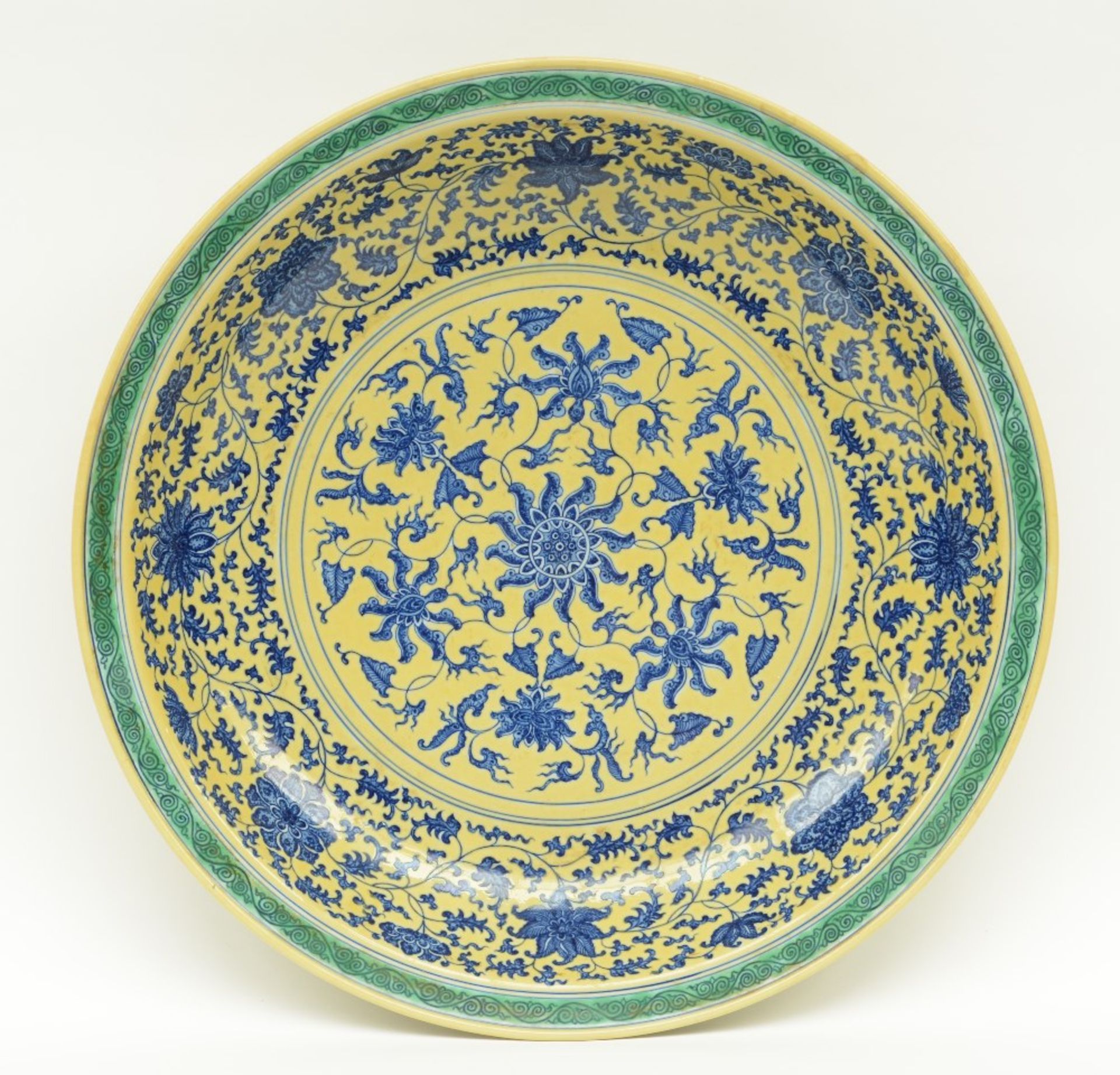 A Chinese large yellow ground and green dish with a blue and white floral decoration, marked