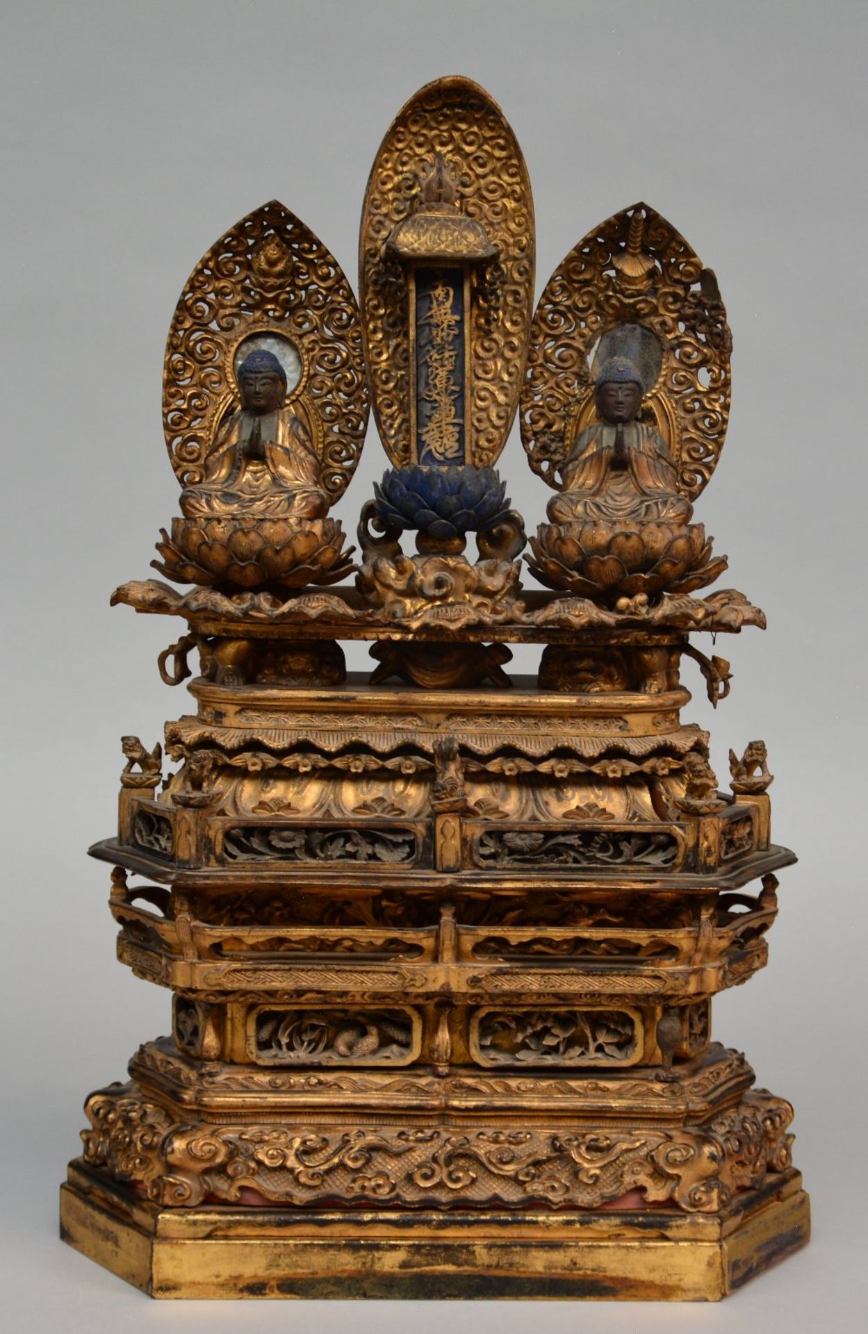 An 18thC Oriental gilt wooden temple with two sitting Buddha's on lotus seat and rich carvings, H 60