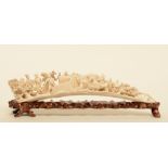 An ivory tusk carved with animated scenes, on a matching wooden base, first half of 20thC, L 45,5 cm