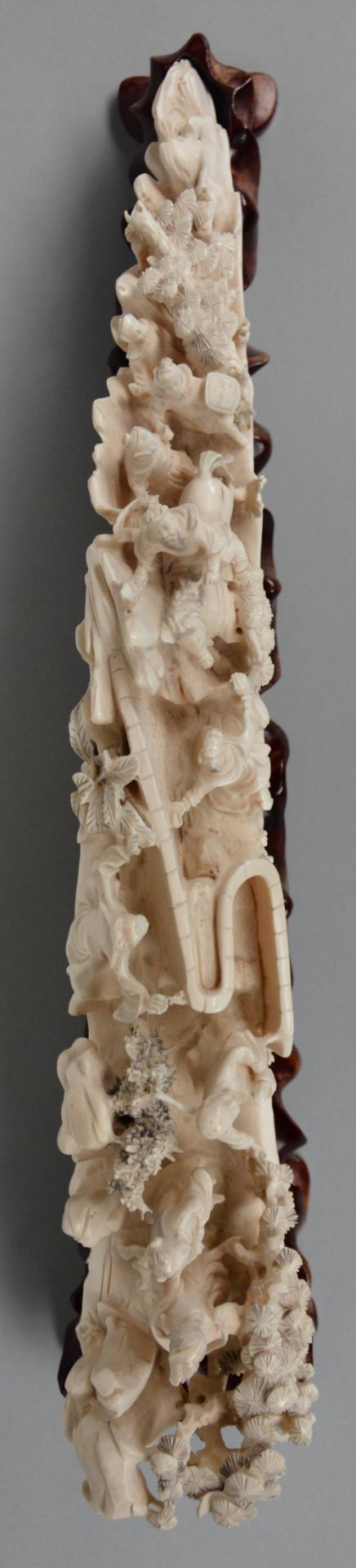 An ivory tusk carved with animated scenes, on a matching wooden base, first half of 20thC, L 45,5 cm - Image 5 of 7