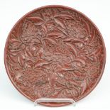 A red Peking lacquered plate with relief decorations, marked, Diameter 35 cm