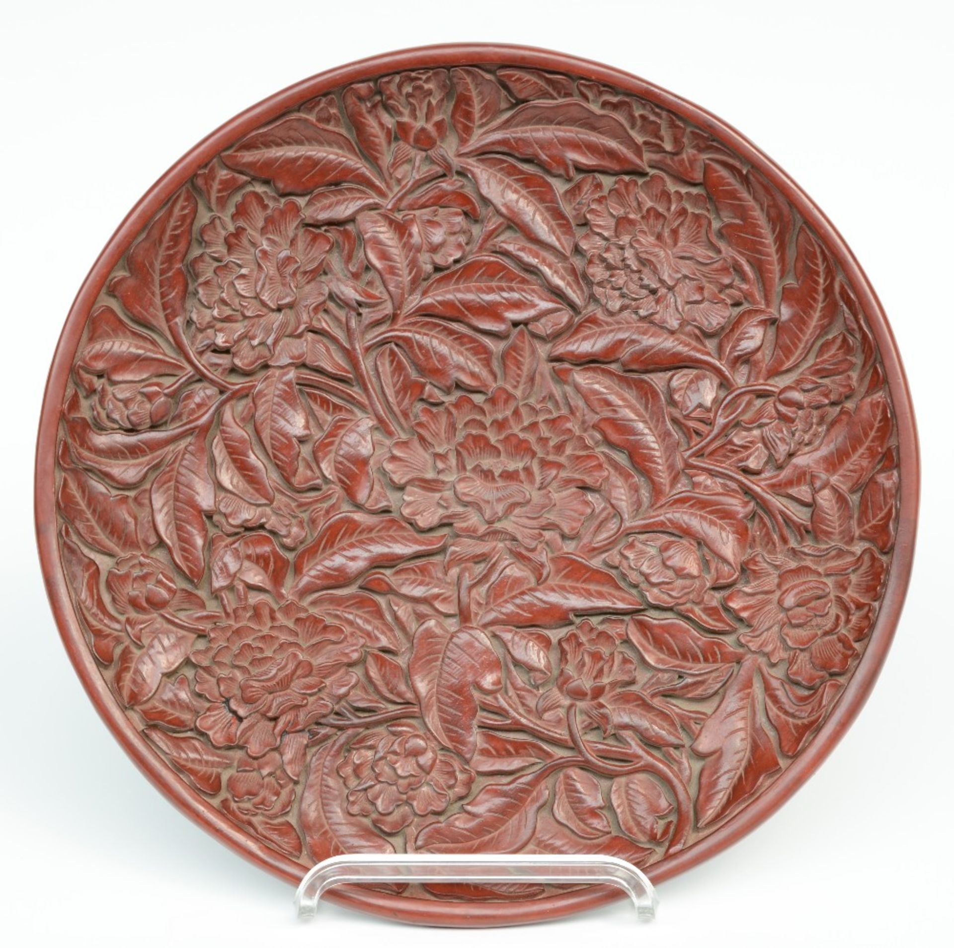 A red Peking lacquered plate with relief decorations, marked, Diameter 35 cm