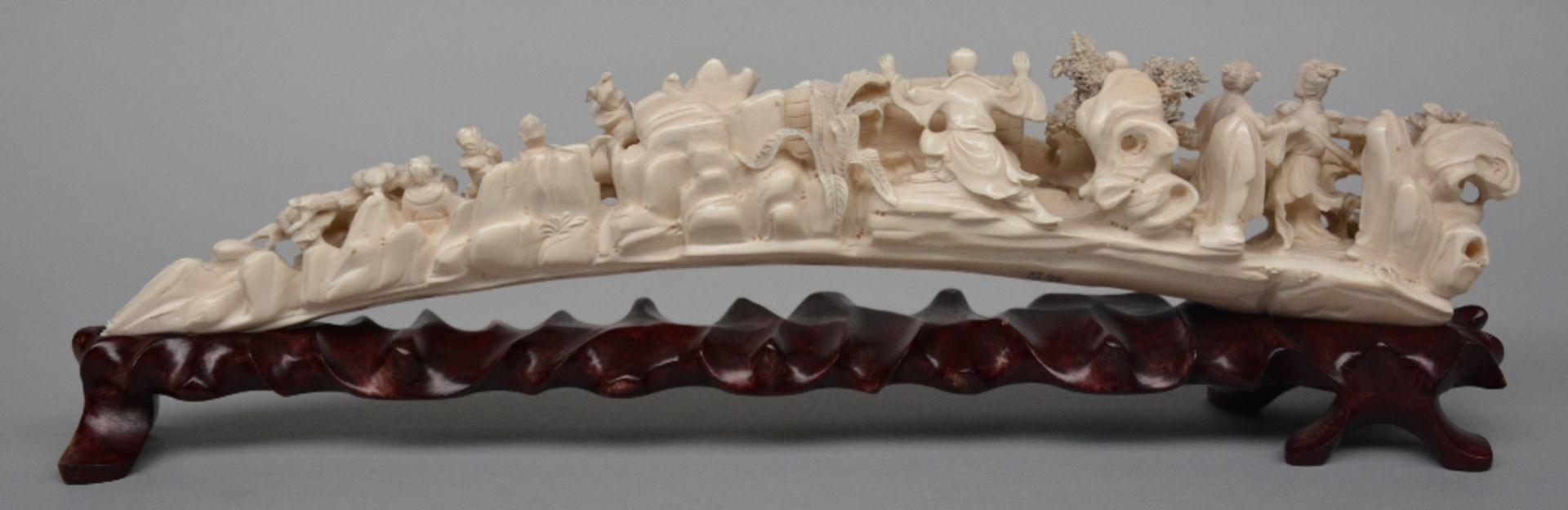 An ivory tusk carved with animated scenes, on a matching wooden base, first half of 20thC, L 45,5 cm - Image 3 of 7