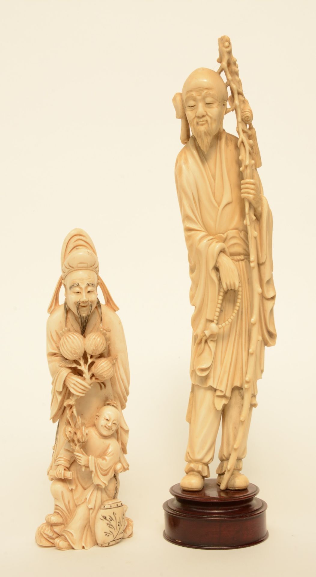 A Chinese ivory figure of a monk, on a wooden base, late Qing period, H 36 cm (whithout base); added