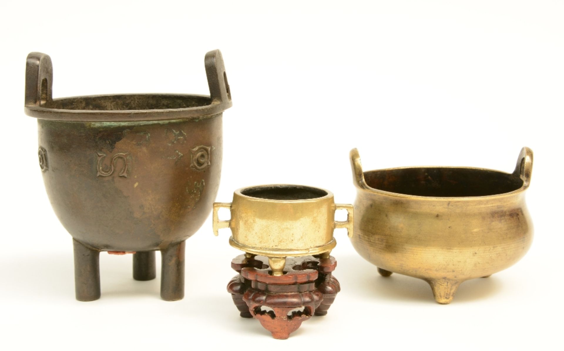 Three Chinese bronze incense burners, one with matching base, two marked, 18thC/19thC, H 3,5 - 13 cm