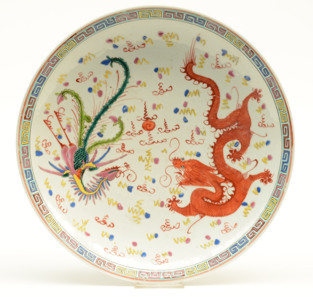 A Chinese polychrome plate, decorated with a dragon, a phoenix and the pearl, 19thC, Diameter 33 cm