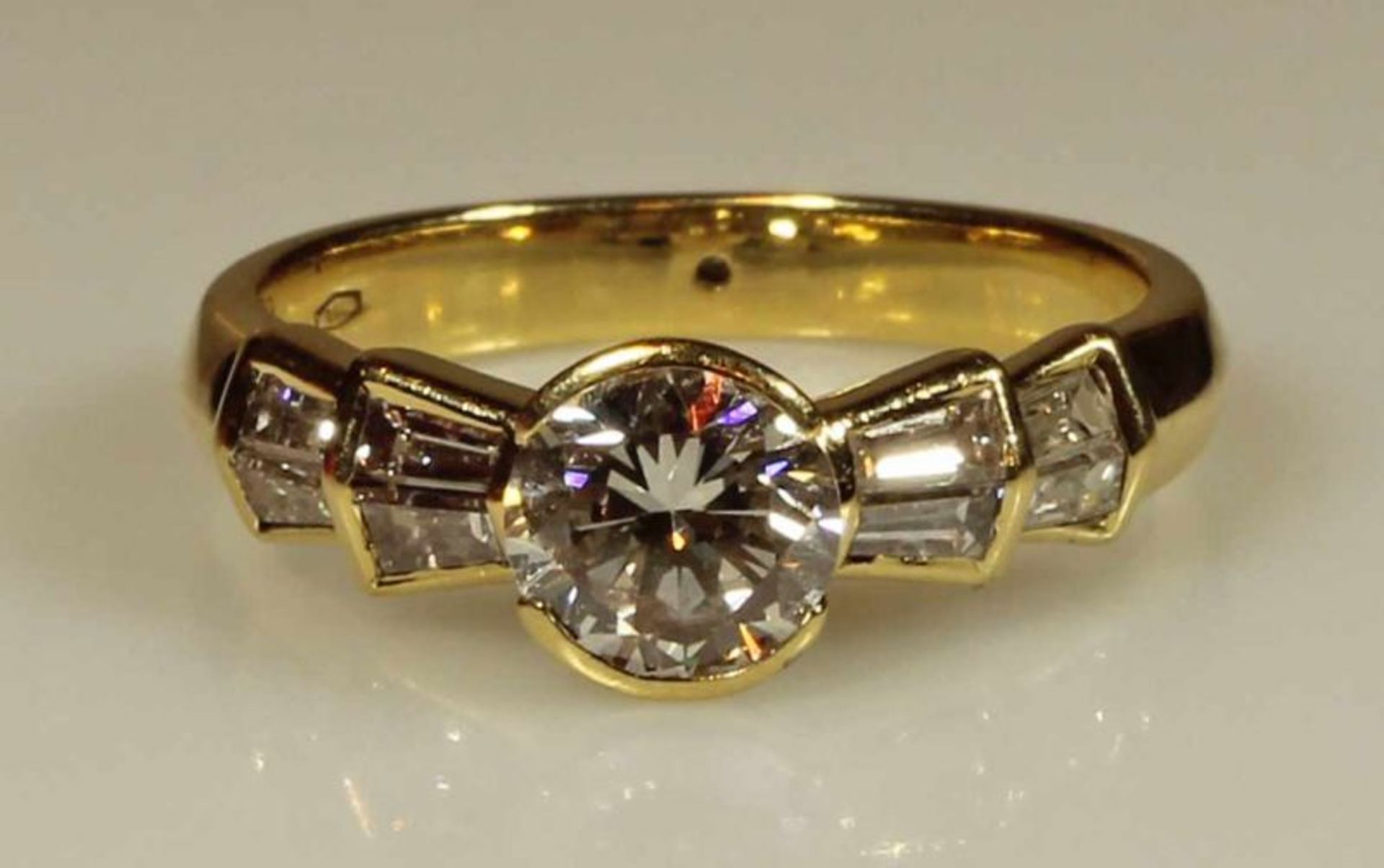 Ring, GG 750, 1 Brillant ca. 1.083 ct., w/vs, 8 Diamant-Trapeze zus. ca. 0.65 ct., etwa tw/vvs, 5 g,