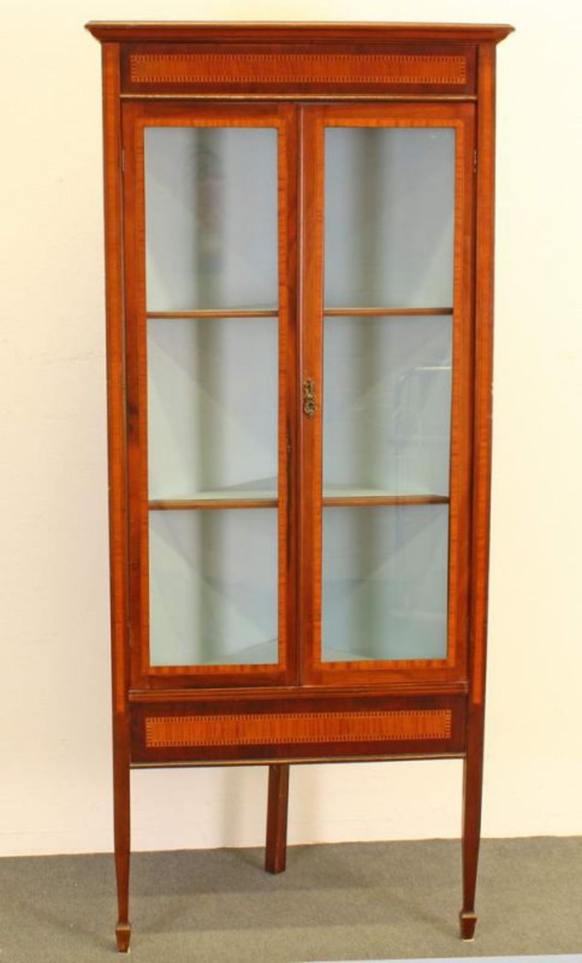 Eckvitrine, England, um 1900, Mahagoni, Bandintarsien, zwei Glastüren, 165 x 53 x 53 cm 20.00 %