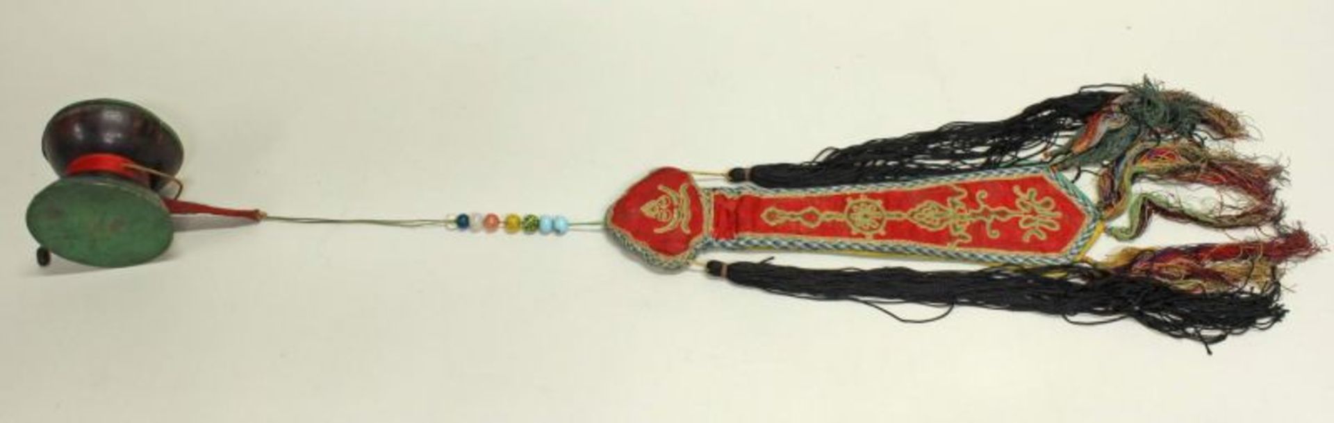 Handtrommel, Tibet, 20. Jh., aus Kokosnuss, grüne Membran, Glasperlen, buntes Banner aus