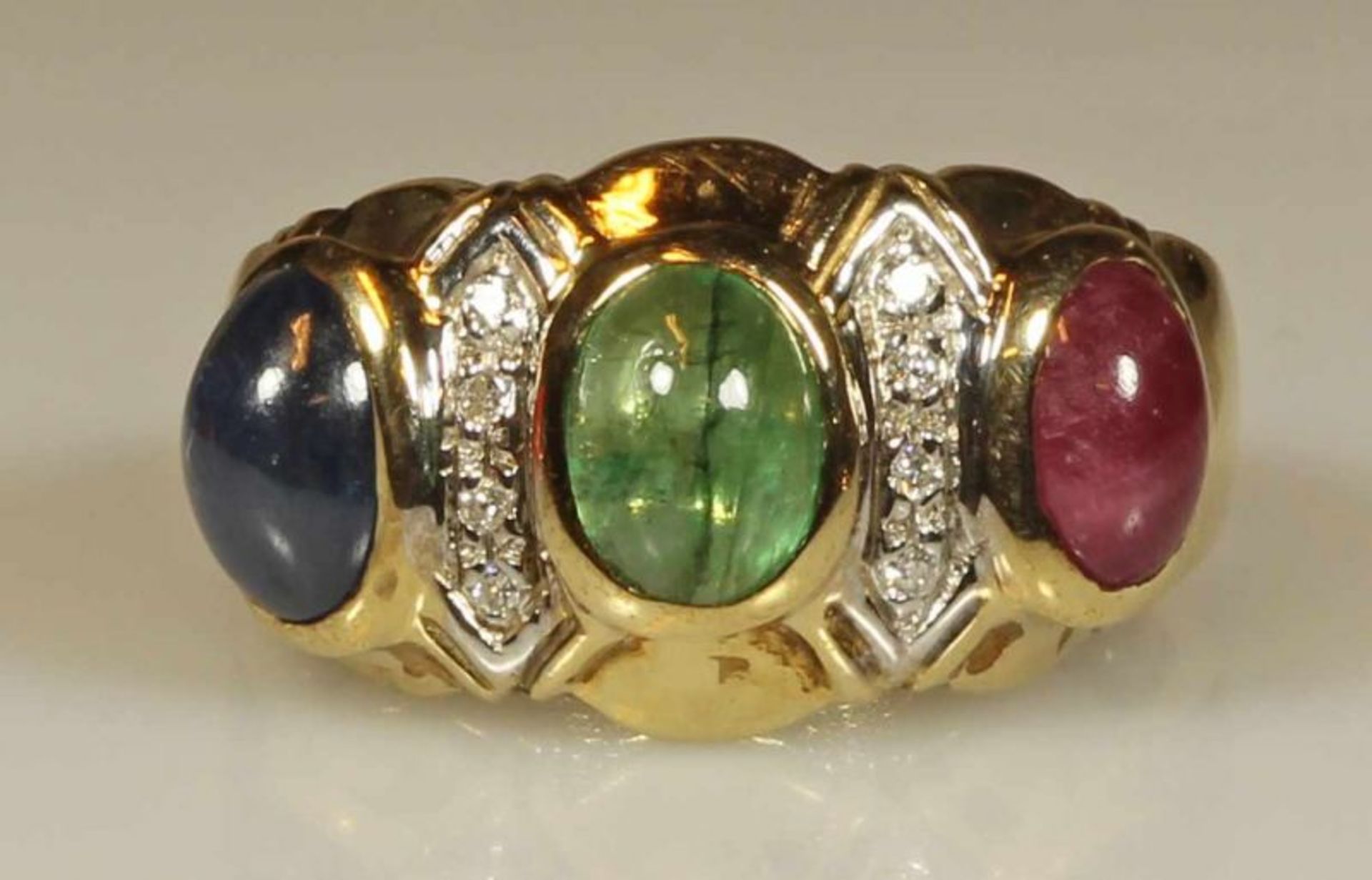 Ring, GG, punziert 375, je 1 ovaler Smaragd-, Saphir- und Rubincabochon, ca. 6.5 x 5 mm, 8