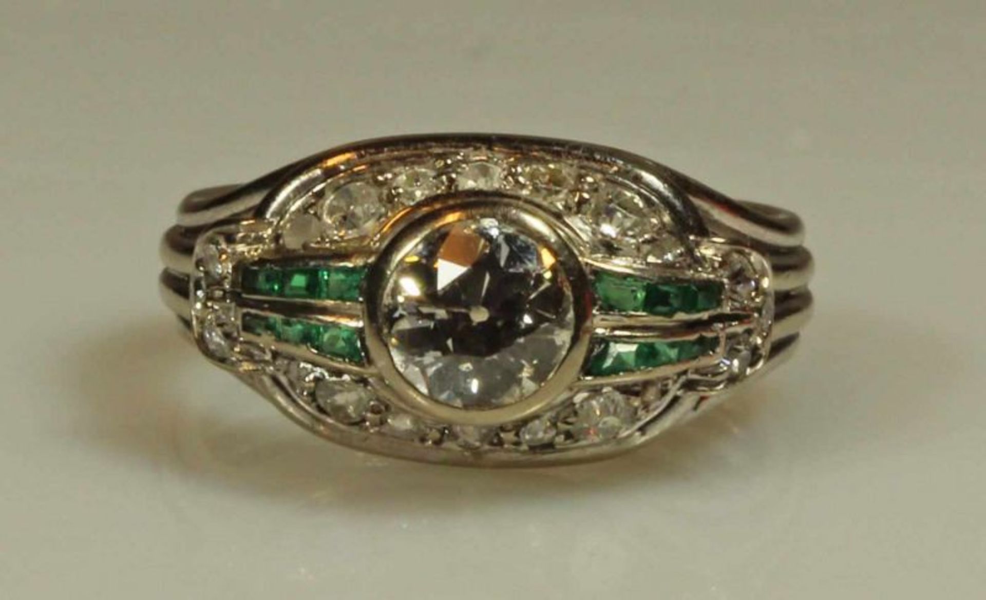 Ring, Art Deco, um 1930, WG 750, 1 Brillanten, ca. 1.0 ct., 20 Diamanten, 12 facettierte Smaragde, 6