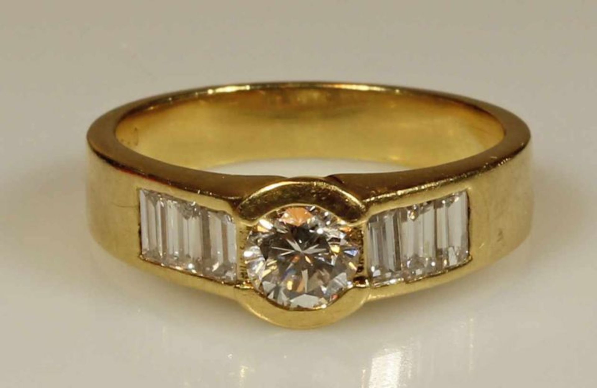 Ring, GG 750, 1 Brillant laut Punzierung 0.59 ct., etwa tw/vsi, 6 Diamantbaguettes zus. laut
