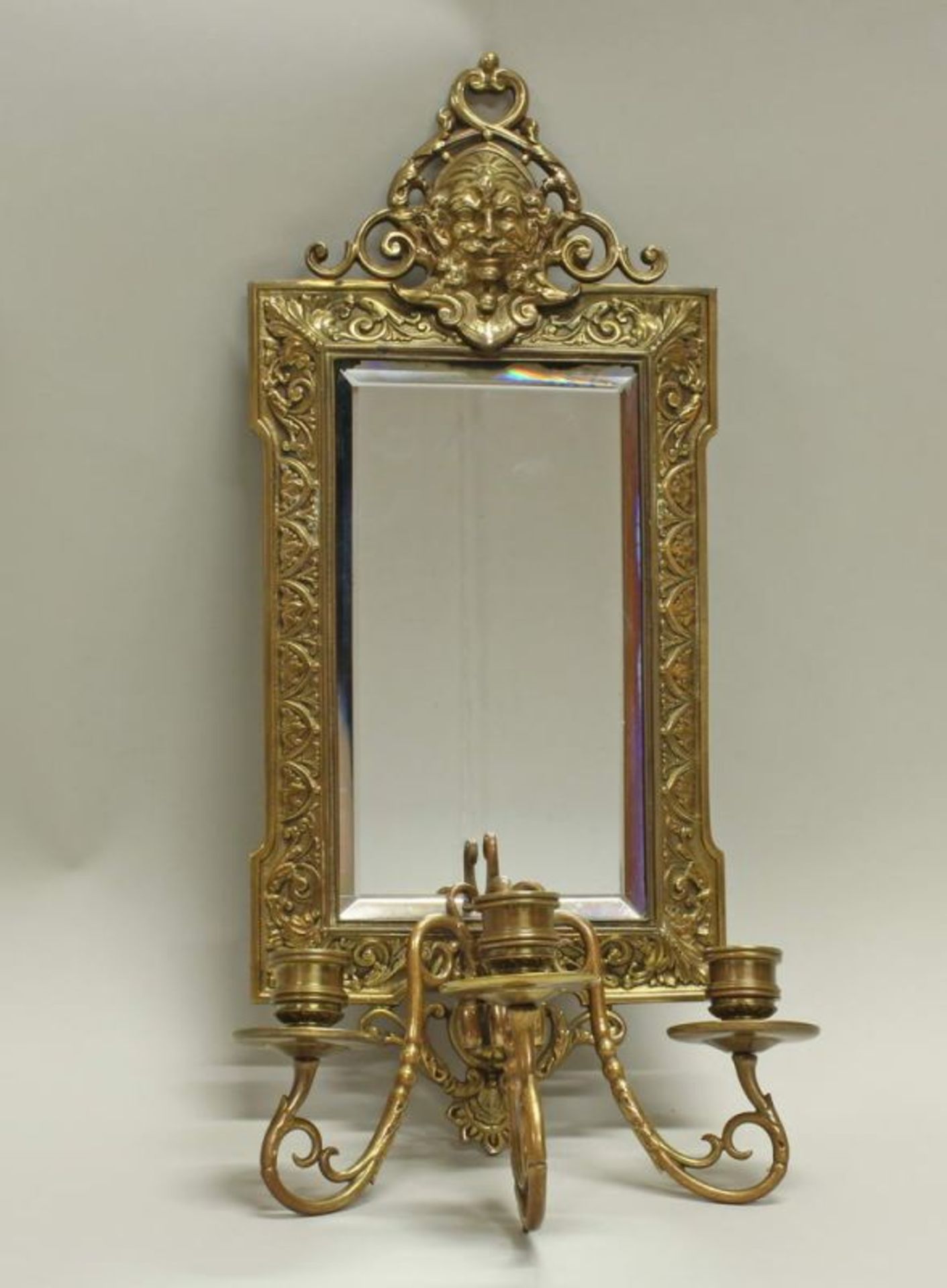 Wandblaker, 20. Jh., Messing, Spiegelglas, Reliefdekor mit männlichem Maskaron, dreiflammig, 45 x 19