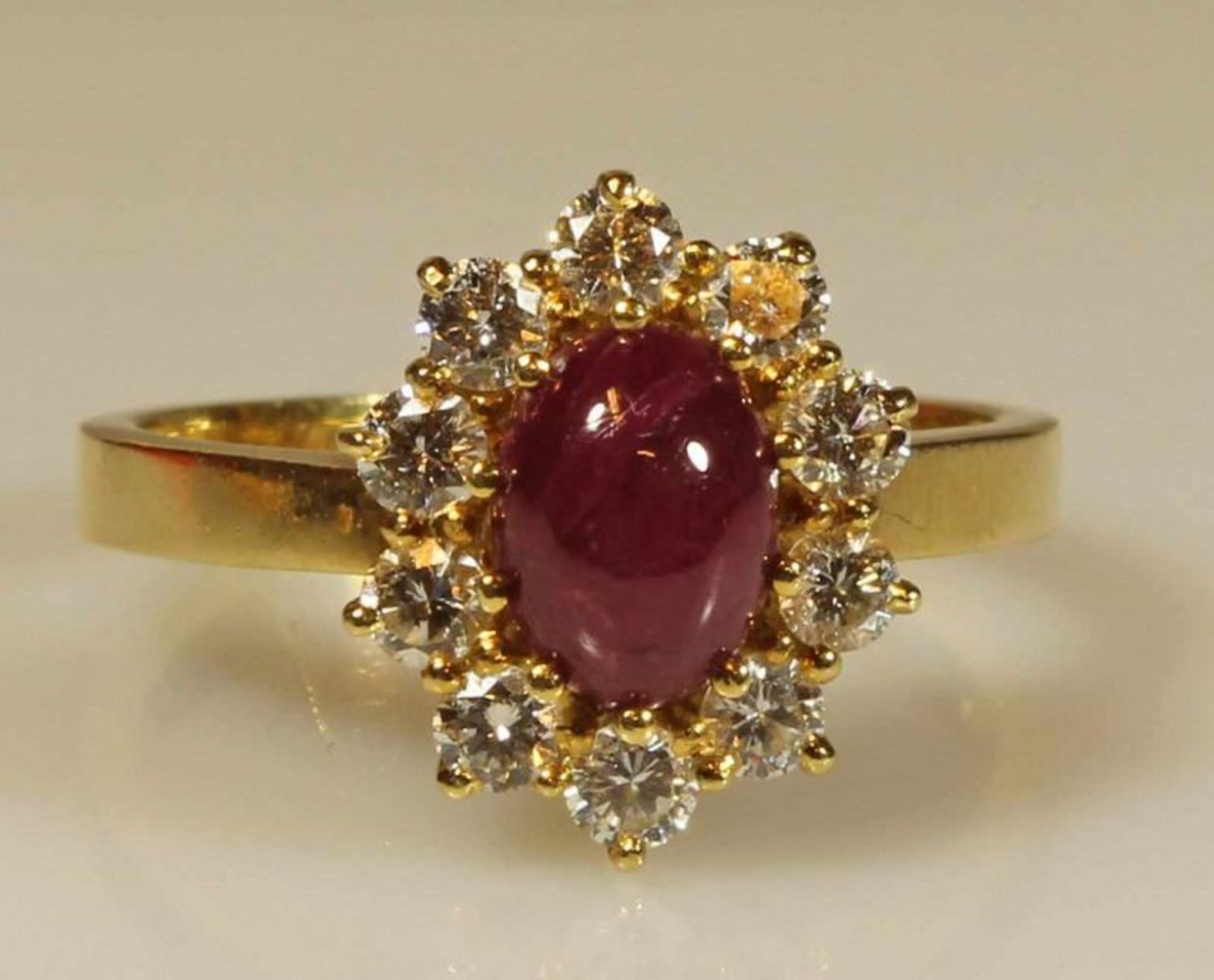 Ring, GG 750, 1 Rubin-Cabochon, 10 Diamanten zus. ca. 0.50 ct., 5 g, RM 18 20.00 % buyer's premium