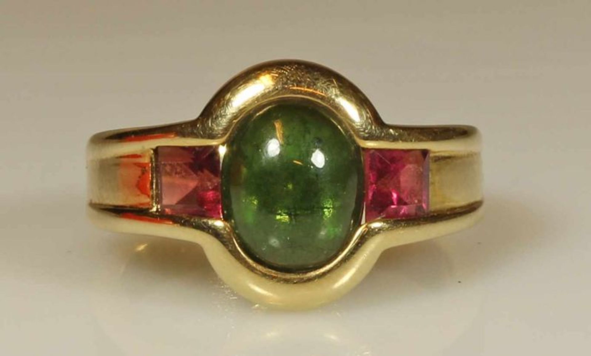 Ring, GG 585, 1 grüner Turmalincabochon, ca. 1.90 ct., 2 pinke Turmalincarrées, zus. ca. 0.80 ct.,