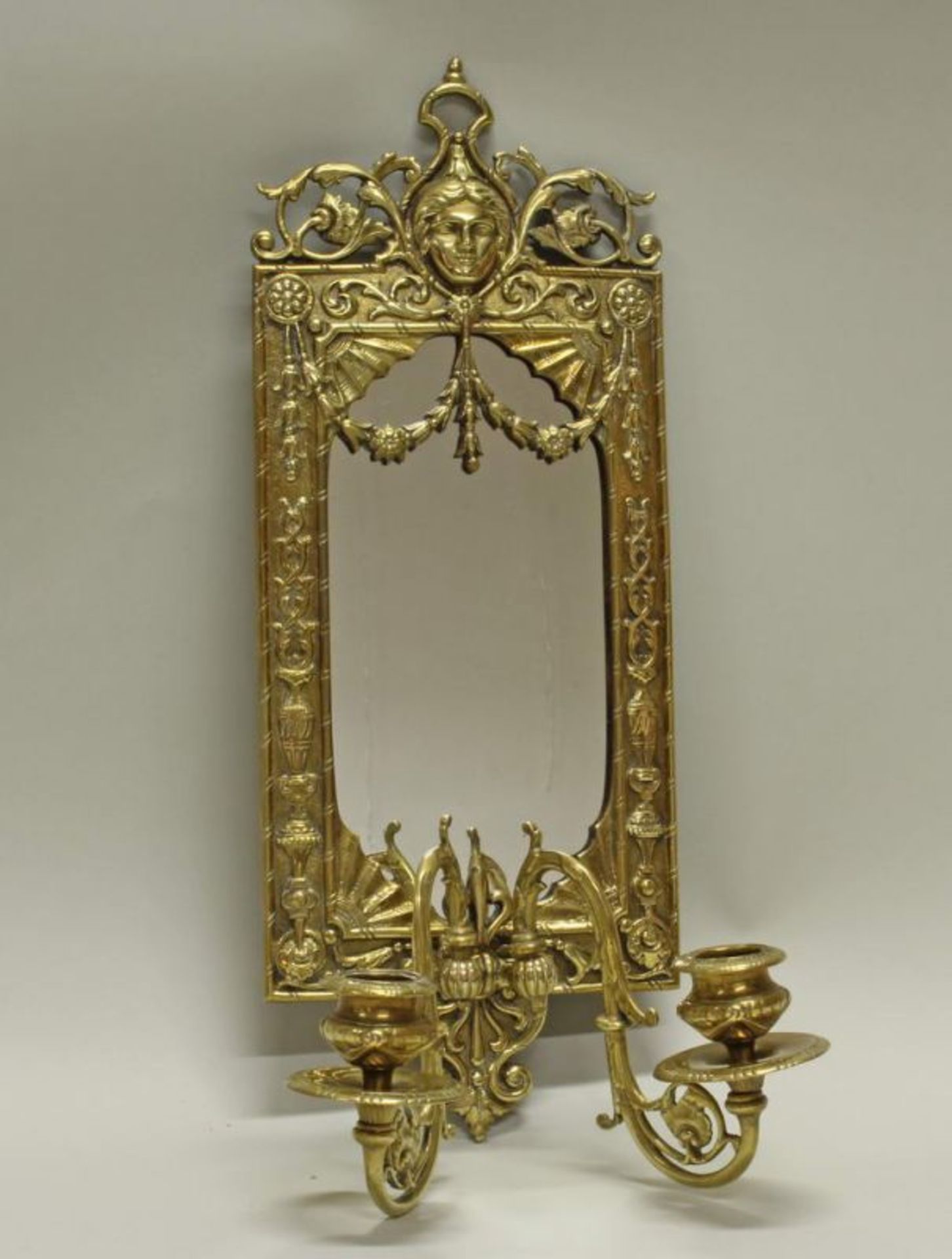 Wandblaker, 20. Jh., Messing, Spiegelglas, Reliefdekor mit Maskaron, zweiflammig, 40 x 15.5 cm 20.00