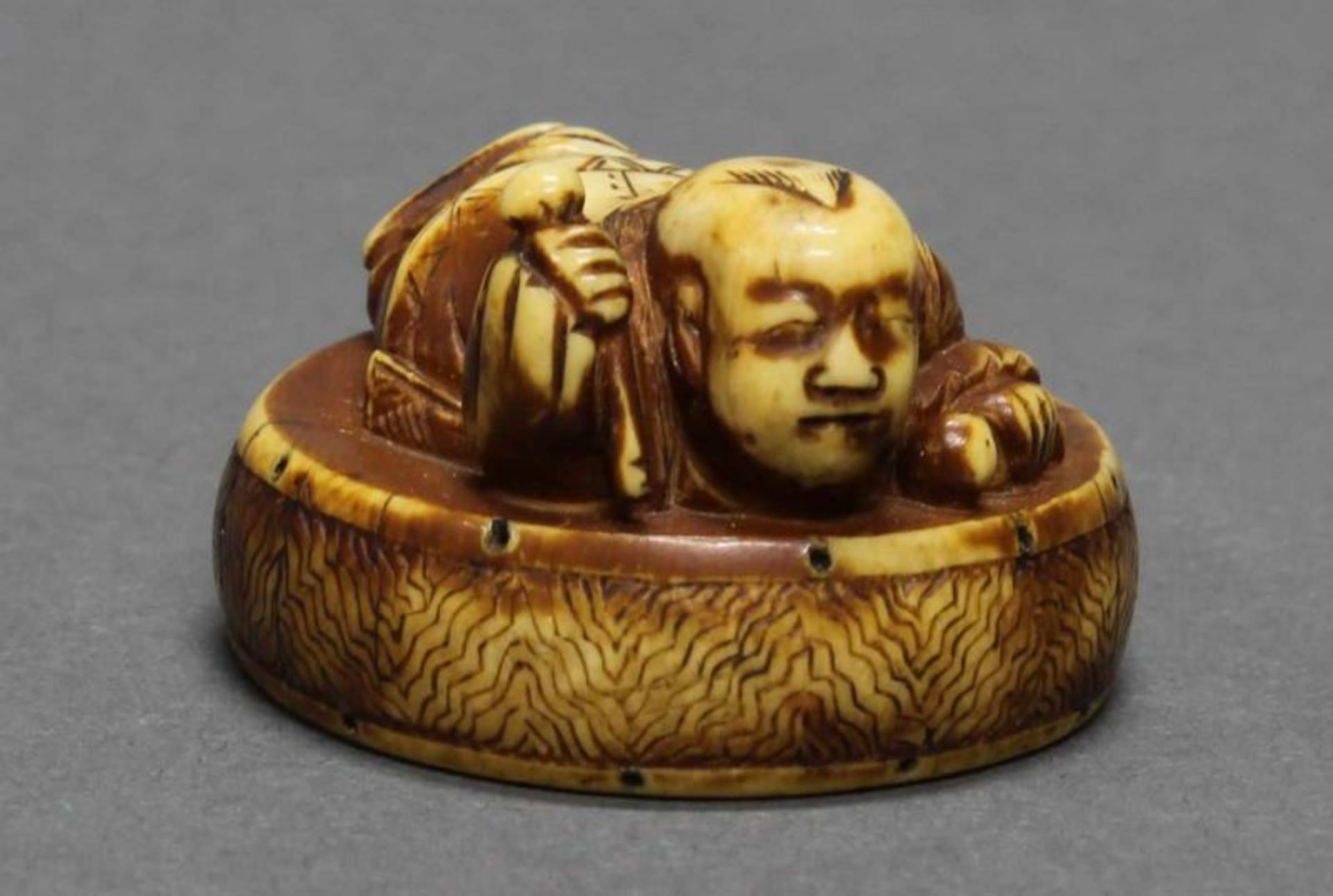 Netsuke, "Junge auf einer Trommel liegend", Japan, 20. Jh., Elfenbein, geschnitzt, 2.2 cm hoch 20.00