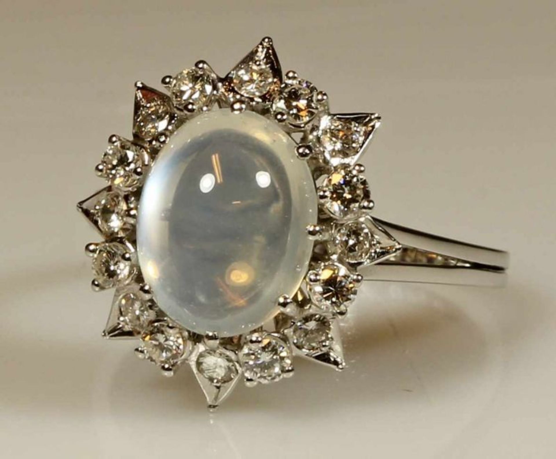 Ring, WG 750, 1 Mondstein-Cabochon, 16 Brillanten zus. ca. 0.56 ct., etwa w/si, 5 g, RM 18.5 20.00 %