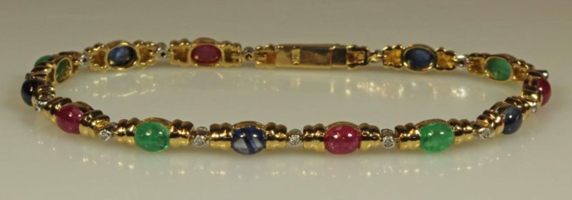 Armband, GG 750, 5 Saphir-, 4 Smaragd- und 4 Rubin-Cabochons, 14 kleine Besatzdiamanten, 18.5 cm