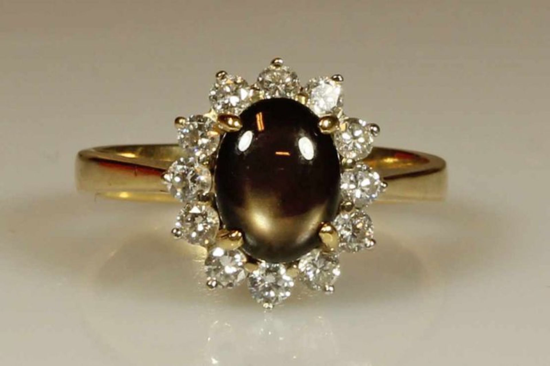 Ring, GG 750, Sternobsidian-Cabochon, 12 Besatzdiamanten, 4 g, RM 16.5 20.00 % buyer's premium on