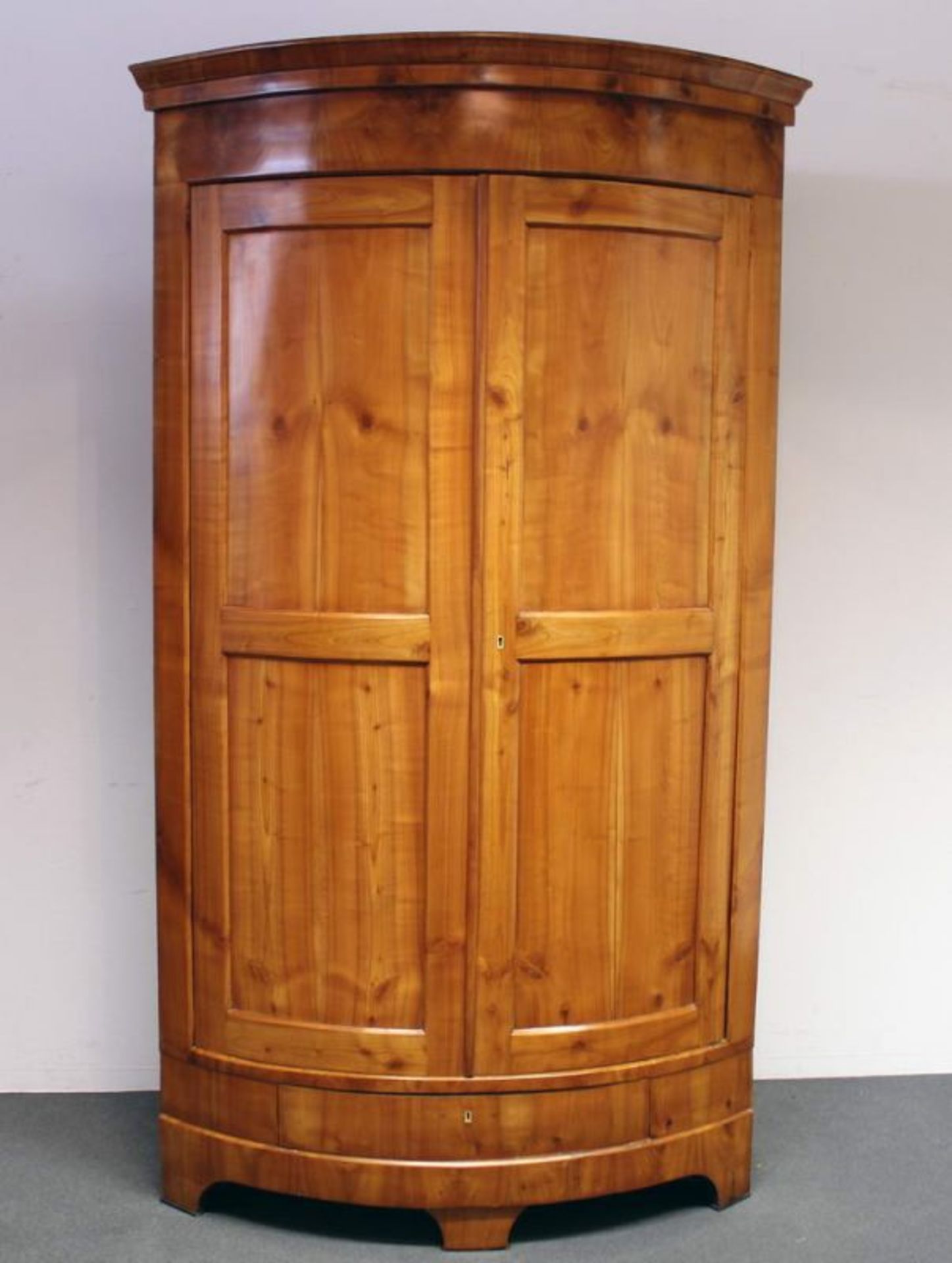 Eckschrank, Biedermeier, wohl südwestdeutsch, um 1830/40, Kirschbaum, gerundete Front, zwei Türen,