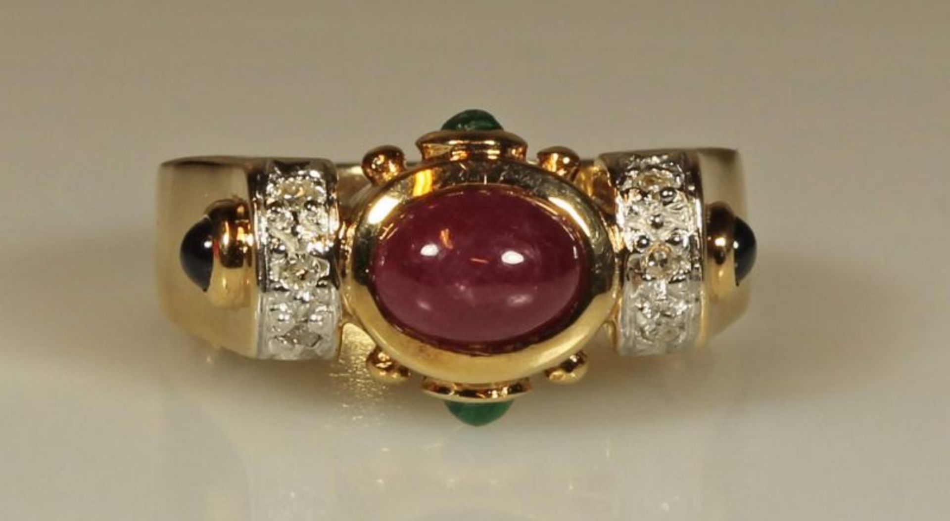 Ring, GG 585, 1 ovaler Rubincabochon, 2 runde Smaragdcabochons, 2 runde Saphircabochons, 6