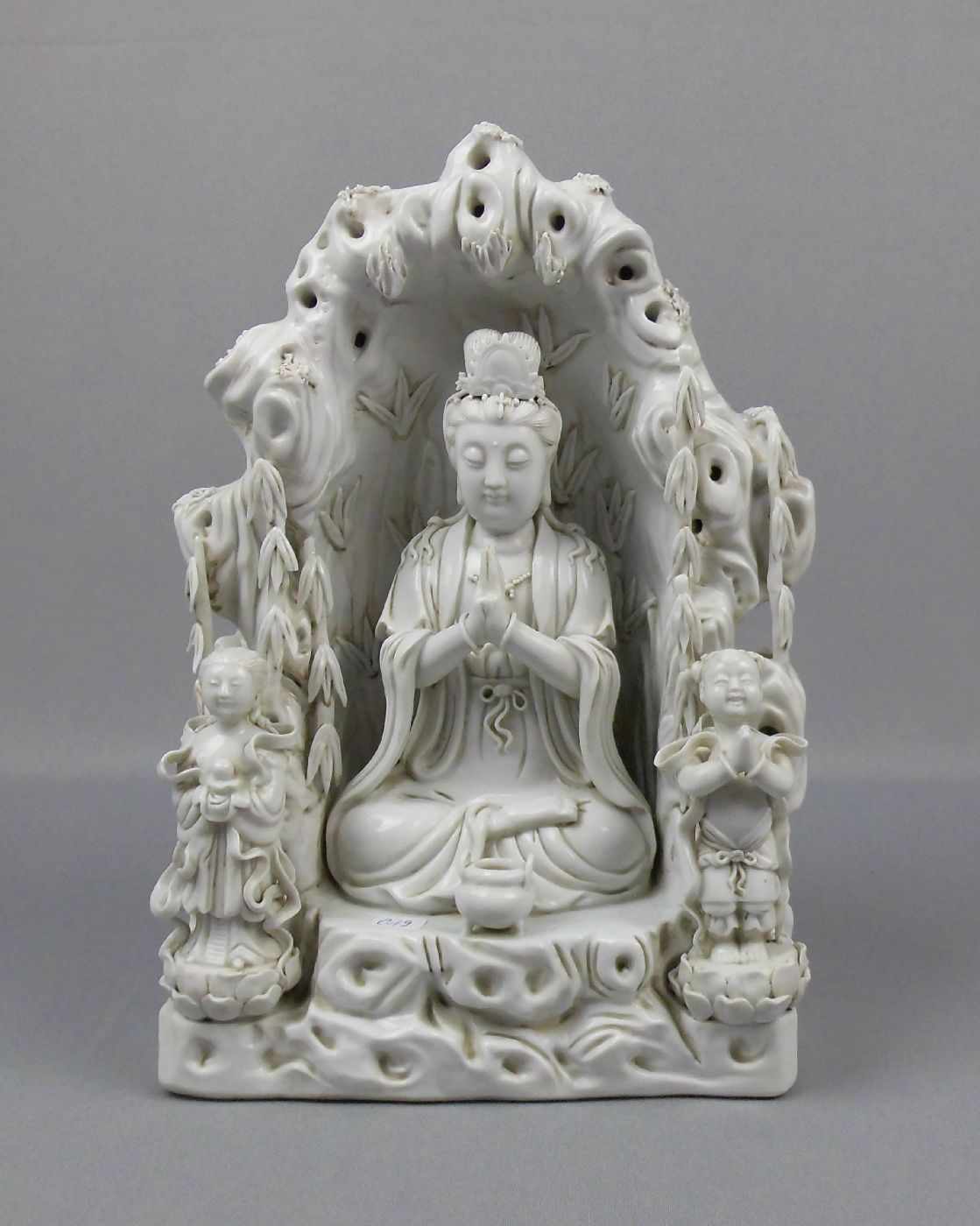 FIGUR: "GUANYIN IN TEMPELGROTTE", China, Blanc de Chine, rückseitig mit mehreren Punzen gemarkt.