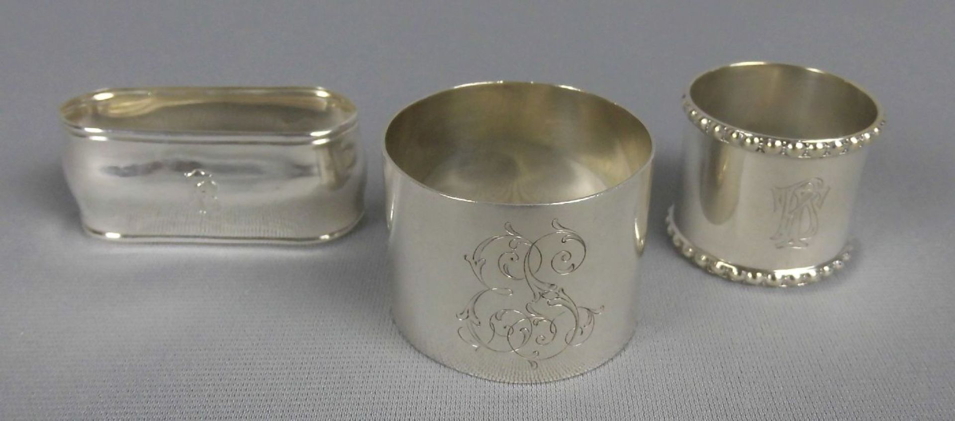 3 SERVIETTENRINGE / napkin rings, unterschiedlicher Form und Größe, 800er und 835er Silber (